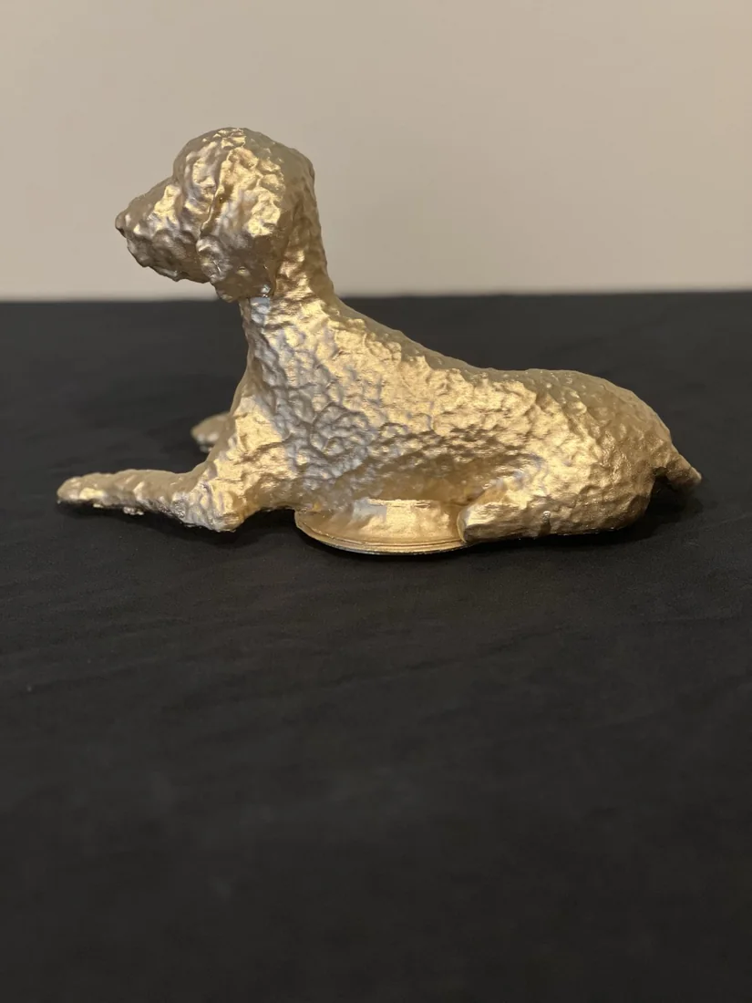 The goldendoodle sculpture at rest, full length.